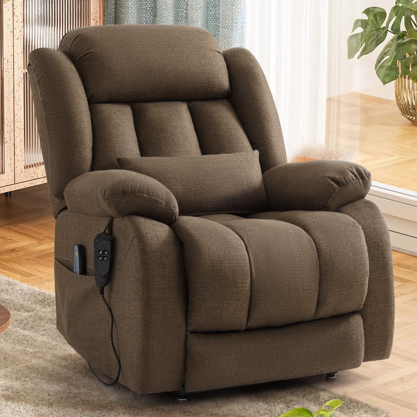 A brown upholstered recliner chair with a matching lumbar pillow, shown in an indoor room. A small control panel is attached to the side of the chair.