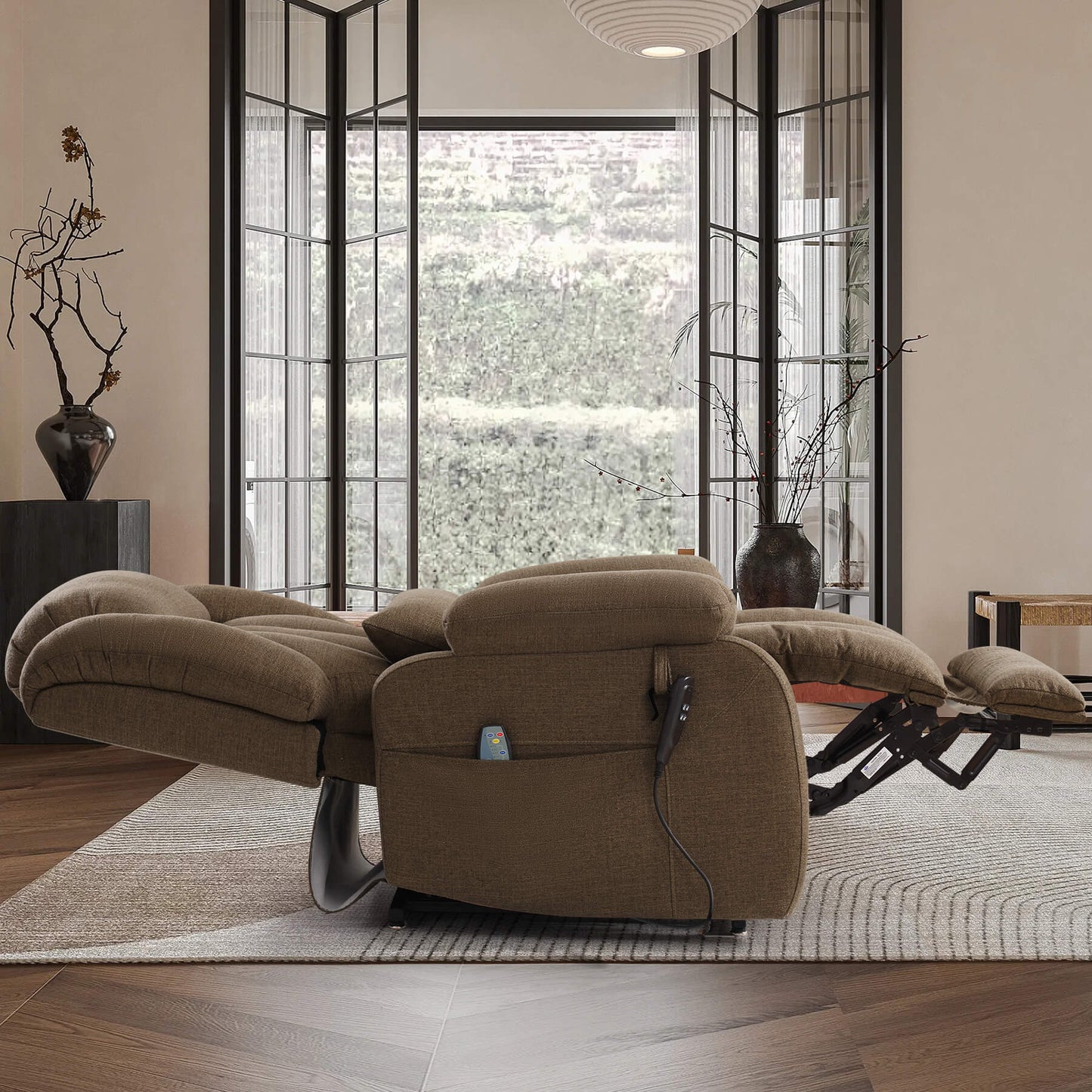 A brown fabric recliner chair with extended footrests and a matching headrest cushion, shown in a fully reclined, flat position in a modern living room.